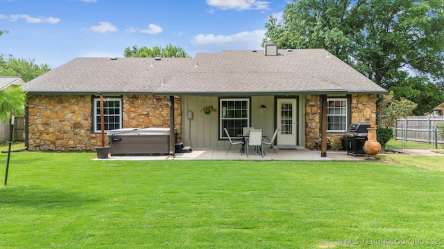 11017 E 98th St N, Owasso, OK 74055 - back of house with a hot tub, stone siding, a patio, and a shingled roof