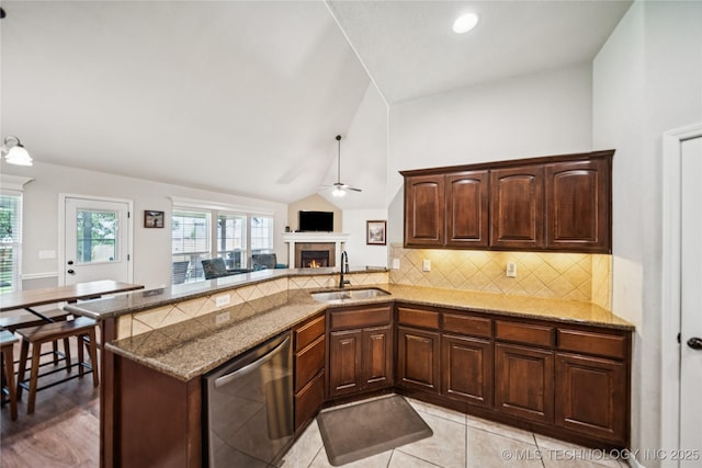 10220 N 119th E Ave, Owasso, OK 74055 - kitchen with dishwasher, ceiling fan, a lit fireplace, a peninsula, and backsplash