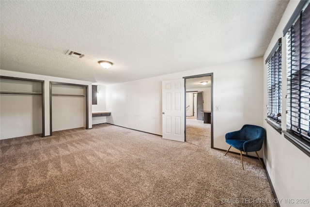 6103 S 223rd E Ave, Broken Arrow, OK 74014 - unfurnished bedroom with a textured ceiling, carpet, and two closets