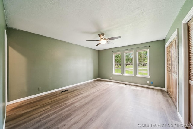 6103 S 223rd E Ave, Broken Arrow, OK 74014 - unfurnished bedroom with wood finished floors, a textured ceiling, and ceiling fan