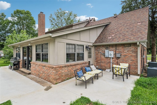 6103 S 223rd E Ave, Broken Arrow, OK 74014 - back of property featuring a patio area, a chimney, an outdoor living space, and brick siding