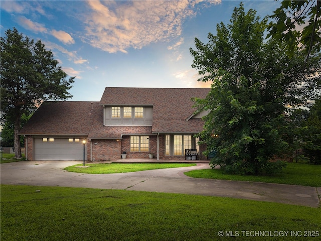 6103 S 223rd E Ave, Broken Arrow, OK 74014 - tudor home featuring driveway, a front yard, a garage, and brick siding