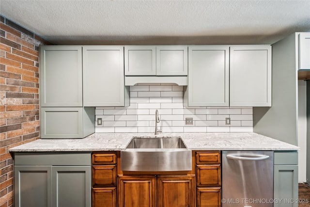 6103 S 223rd E Ave, Broken Arrow, OK 74014 - kitchen featuring a textured ceiling, brick wall, light stone counters, stainless steel dishwasher, and backsplash