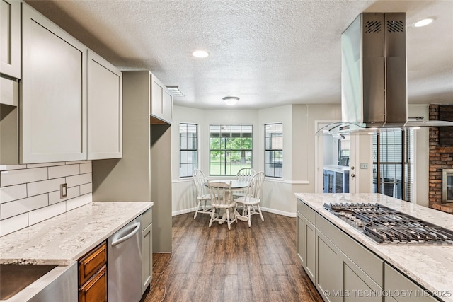 6103 S 223rd E Ave, Broken Arrow, OK 74014 - kitchen featuring island exhaust hood, stainless steel appliances, dark wood-type flooring, decorative backsplash, and a textured ceiling
