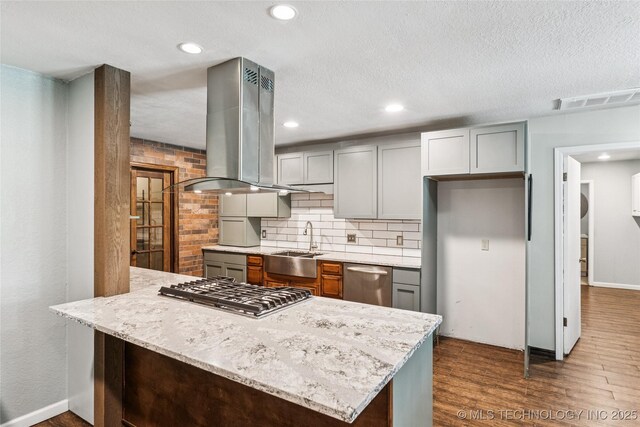 6103 S 223rd E Ave, Broken Arrow, OK 74014 - kitchen with island range hood, appliances with stainless steel finishes, dark wood-style floors, a peninsula, and tasteful backsplash