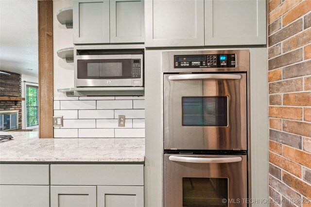 6103 S 223rd E Ave, Broken Arrow, OK 74014 - kitchen with stainless steel appliances, backsplash, and light stone countertops