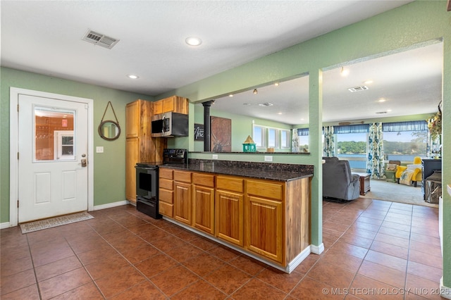 61112 E 310, Grove, OK 74344 - kitchen featuring black / electric stove, stainless steel microwave, decorative columns, a peninsula, and dark tile patterned flooring