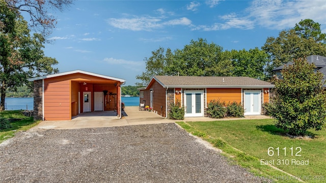 61112 E 310, Grove, OK 74344 - view of front of house with french doors, gravel driveway, a front lawn, and a carport