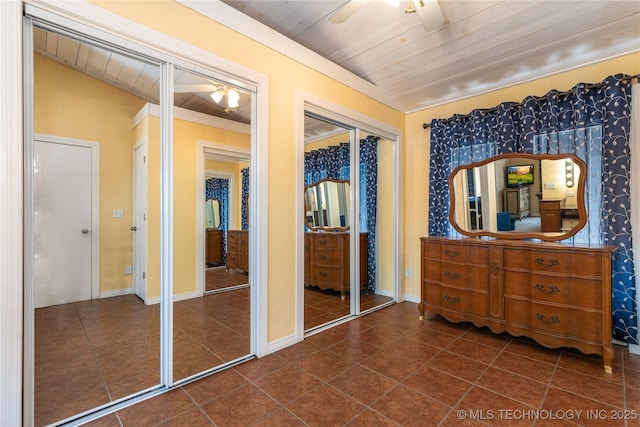 61112 E 310, Grove, OK 74344 - bedroom with wood ceiling, dark tile patterned flooring, multiple closets, and stainless steel refrigerator with ice dispenser