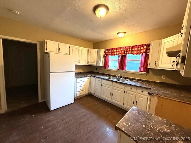 904 W Corporation St, Henryetta, OK 74437 - kitchen with freestanding refrigerator, a textured ceiling, dark countertops, extractor fan, and white cabinetry