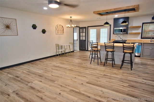 1424 E Okmulgee St, Muskogee, OK 74403 - kitchen featuring appliances with stainless steel finishes, light wood-style floors, ceiling fan, butcher block countertops, and a breakfast bar