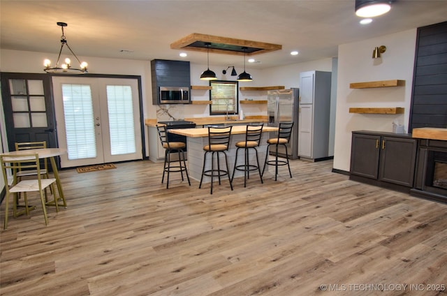 1424 E Okmulgee St, Muskogee, OK 74403 - kitchen with open shelves, appliances with stainless steel finishes, a kitchen breakfast bar, light wood-type flooring, and recessed lighting