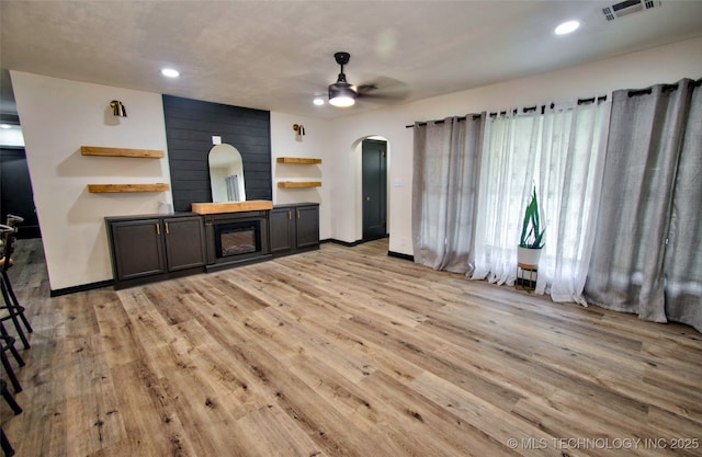 1424 E Okmulgee St, Muskogee, OK 74403 - unfurnished living room featuring arched walkways, a ceiling fan, light wood-style flooring, a fireplace, and recessed lighting