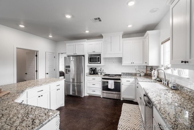 8486 Mcduffee Rd, Kingston, OK 73439 - kitchen featuring appliances with stainless steel finishes, white cabinets, decorative backsplash, and recessed lighting