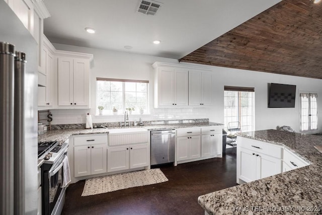 8486 Mcduffee Rd, Kingston, OK 73439 - kitchen with stainless steel appliances, backsplash, white cabinetry, light stone countertops, and recessed lighting