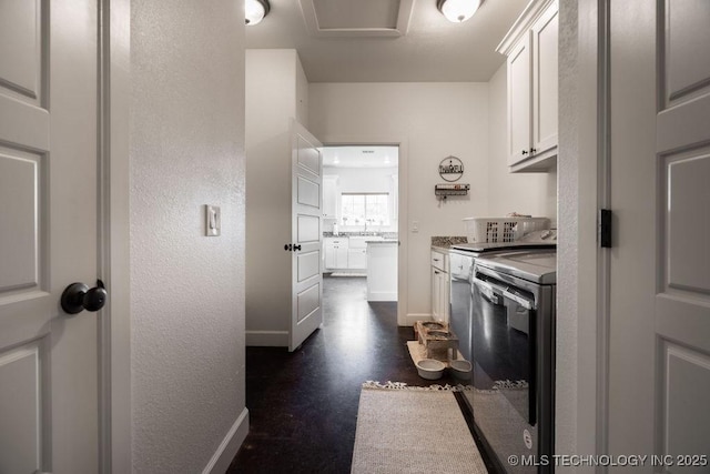 8486 Mcduffee Rd, Kingston, OK 73439 - kitchen featuring white cabinetry, dishwashing machine, and a textured wall
