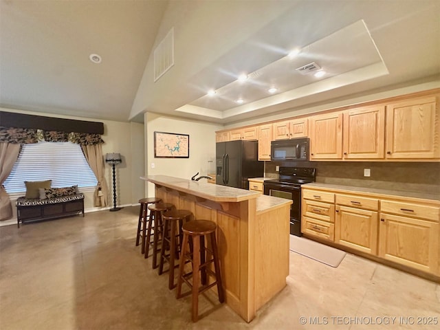 1908 Rhynes-Childress Loop, Kingston, OK 73439 - kitchen featuring black appliances, light brown cabinets, a raised ceiling, a breakfast bar, and light countertops