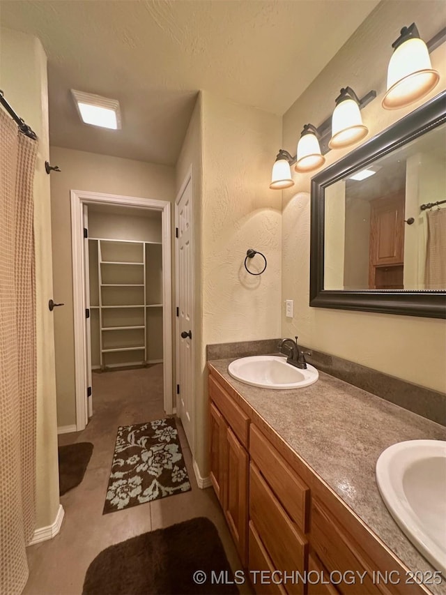 1908 Rhynes-Childress Loop, Kingston, OK 73439 - bathroom featuring double vanity, a spacious closet, and curtained shower