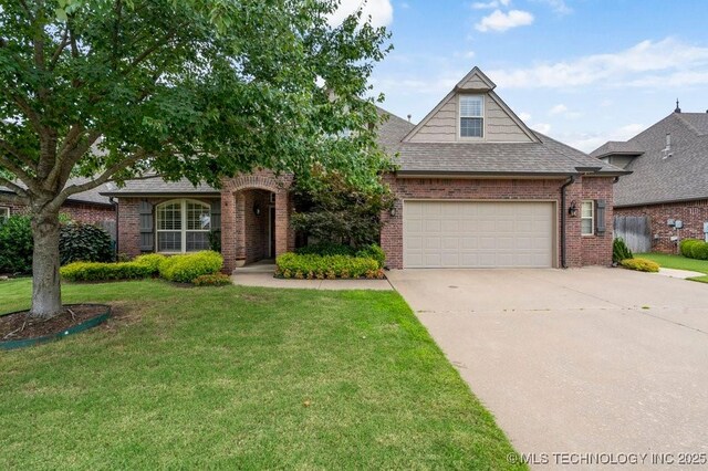 14404 S Florence Ave, Bixby, OK 74008 - view of front of home featuring brick siding, concrete driveway, a front yard, a shingled roof, and an attached garage