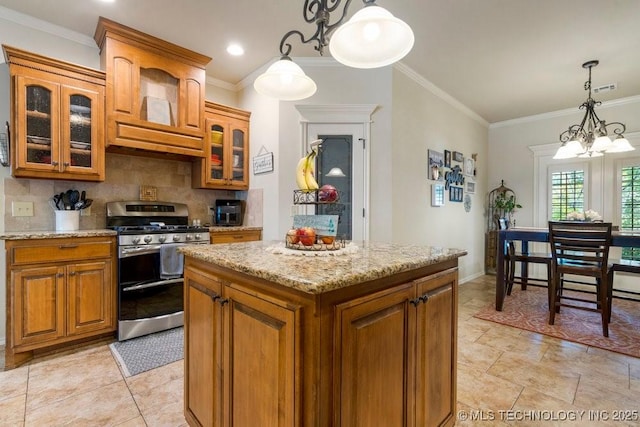 14404 S Florence Ave, Bixby, OK 74008 - kitchen featuring stainless steel gas range, brown cabinets, tasteful backsplash, a chandelier, and light stone counters