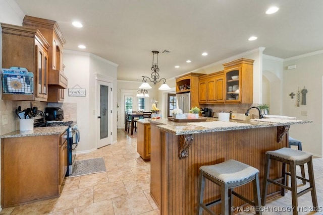 14404 S Florence Ave, Bixby, OK 74008 - kitchen featuring appliances with stainless steel finishes, brown cabinetry, a breakfast bar, a peninsula, and glass insert cabinets