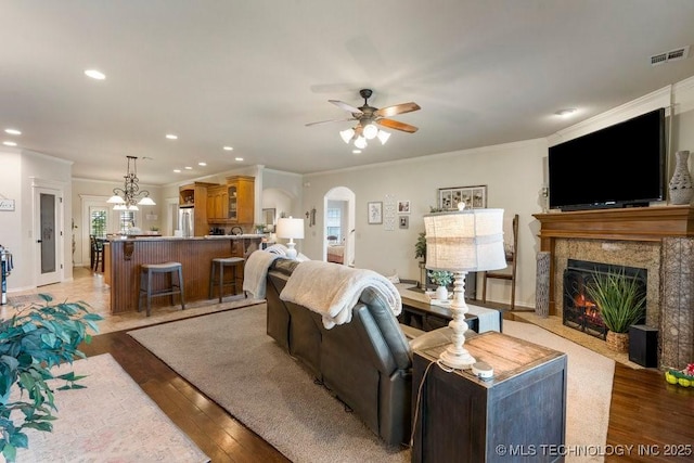 14404 S Florence Ave, Bixby, OK 74008 - living area featuring a ceiling fan, ornamental molding, a high end fireplace, light wood finished floors, and arched walkways