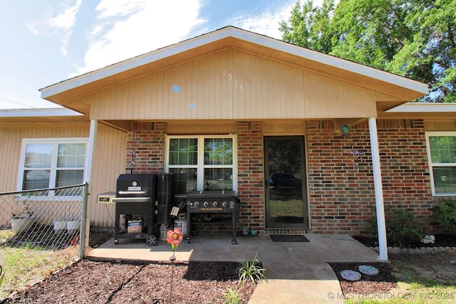 1518 E Hogner St, Tahlequah, OK 74464 - doorway to property featuring brick siding and a patio area
