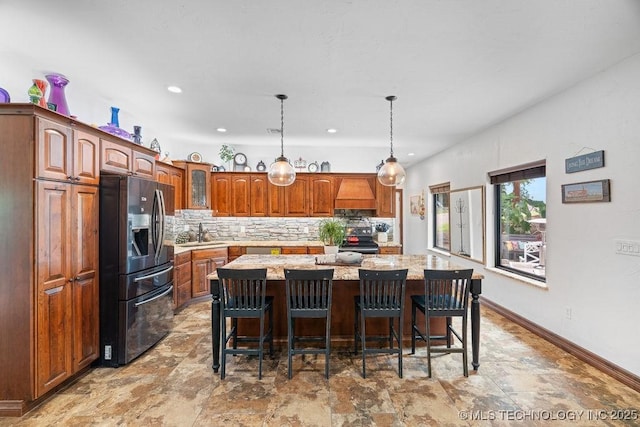 9094 Waters Edge, Kingston, OK 73439 - kitchen featuring fridge with ice dispenser, black range with electric stovetop, custom range hood, backsplash, and a center island