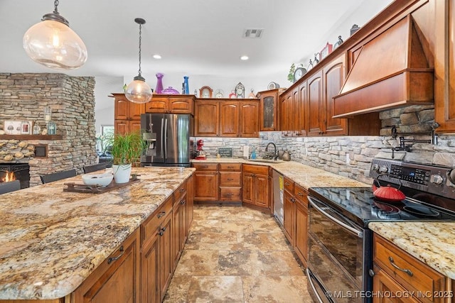 9094 Waters Edge, Kingston, OK 73439 - kitchen featuring appliances with stainless steel finishes, tasteful backsplash, light stone finish floors, light stone countertops, and decorative light fixtures