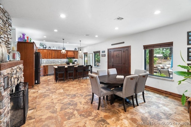 9094 Waters Edge, Kingston, OK 73439 - dining room with a fireplace, recessed lighting, and light stone finish floors