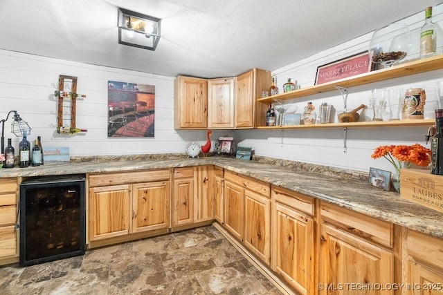 9094 Waters Edge, Kingston, OK 73439 - indoor dry bar featuring stone finish floors, a textured ceiling, and black fridge