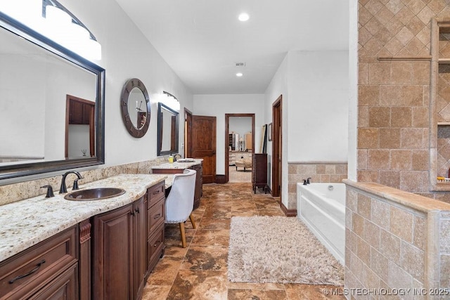 9094 Waters Edge, Kingston, OK 73439 - bathroom with a bath, two vanities, stone finish flooring, and recessed lighting