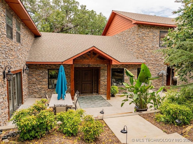 9094 Waters Edge, Kingston, OK 73439 - doorway to property with stone siding and a shingled roof