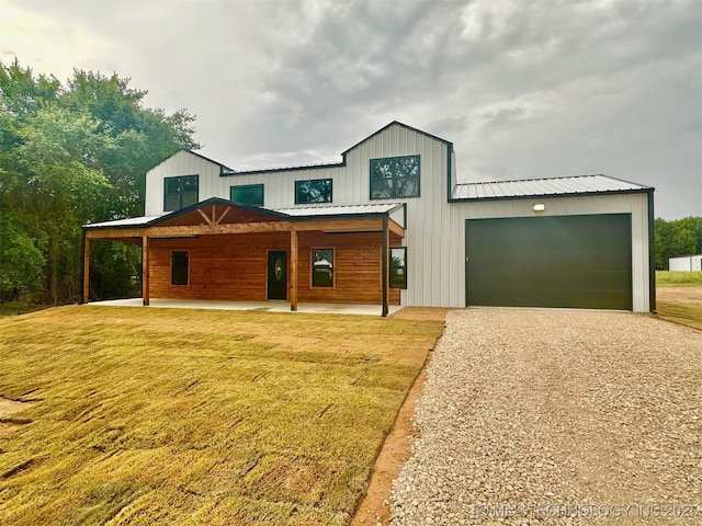 11743 Xander Ln, Kingston, OK 73439 - view of front facade with driveway, a front lawn, a metal roof, a garage, and board and batten siding