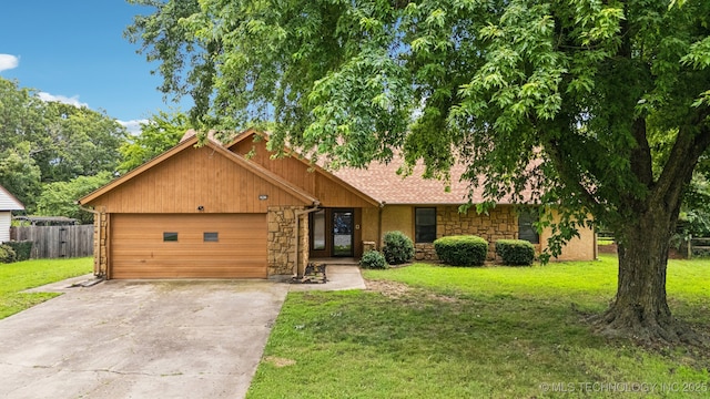 6947 S 30th W Ave, Tulsa, OK 74132 - view of front of property featuring an attached garage, concrete driveway, and stone siding