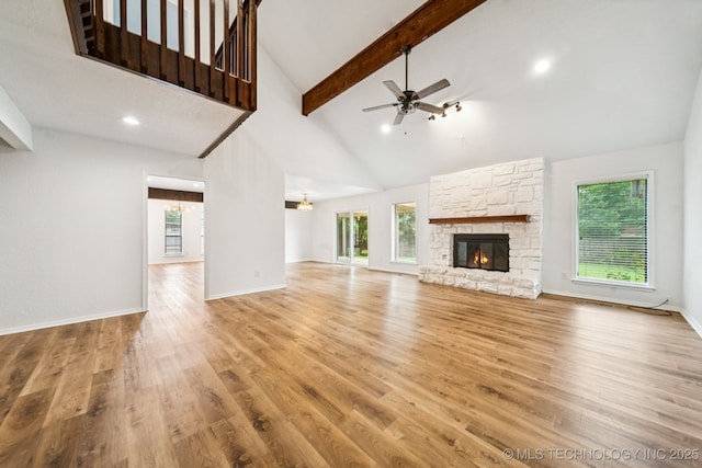 6947 S 30th W Ave, Tulsa, OK 74132 - unfurnished living room with beamed ceiling, healthy amount of natural light, a fireplace, a ceiling fan, and light wood-type flooring