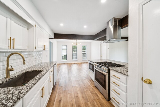 6947 S 30th W Ave, Tulsa, OK 74132 - kitchen featuring island exhaust hood, appliances with stainless steel finishes, light wood-style floors, white cabinets, and a chandelier