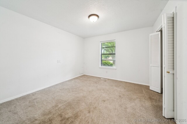 6947 S 30th W Ave, Tulsa, OK 74132 - unfurnished bedroom featuring carpet and a textured ceiling