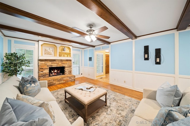 10958 S Richmond Ave, Tulsa, OK 74137 - living area featuring beam ceiling, a ceiling fan, wood finished floors, a fireplace, and a wainscoted wall