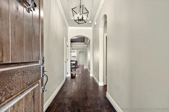 14505 E 79th St, Owasso, OK 74055 - hall featuring arched walkways, ornamental molding, dark wood-style flooring, and a chandelier