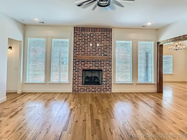 5657 E 141st Pl N, Collinsville, OK 74021 - unfurnished living room featuring a ceiling fan, wood finished floors, healthy amount of natural light, and a fireplace