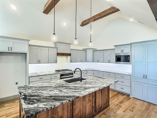 5657 E 141st Pl N, Collinsville, OK 74021 - kitchen with stainless steel microwave, high vaulted ceiling, beam ceiling, light wood-style floors, and gray cabinetry