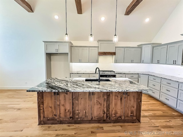 5657 E 141st Pl N, Collinsville, OK 74021 - kitchen with beam ceiling, light stone countertops, backsplash, a center island with sink, and high vaulted ceiling