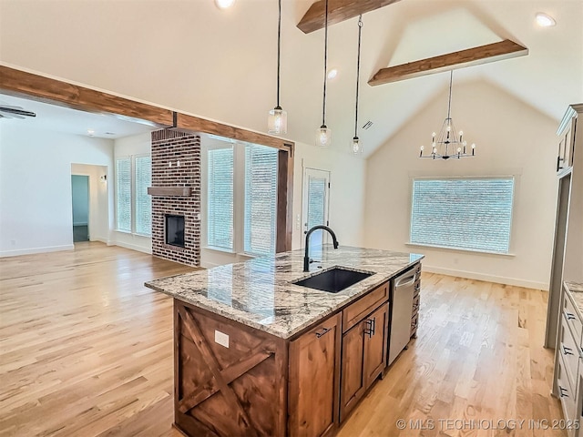 5657 E 141st Pl N, Collinsville, OK 74021 - kitchen featuring dishwasher, beamed ceiling, light wood-style flooring, open floor plan, and a fireplace