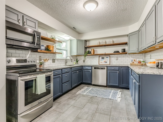 3609 Dana Dr, Bartlesville, OK 74006 - kitchen featuring stainless steel appliances, open shelves, a textured ceiling, and tasteful backsplash