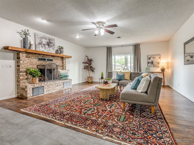 3609 Dana Dr, Bartlesville, OK 74006 - living room with ceiling fan, a textured ceiling, a fireplace, and wood finished floors