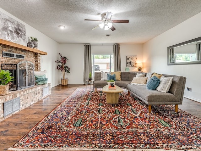 3609 Dana Dr, Bartlesville, OK 74006 - living room featuring a ceiling fan, a brick fireplace, wood finished floors, and a textured ceiling