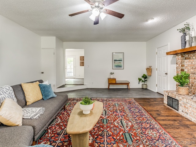 3609 Dana Dr, Bartlesville, OK 74006 - living area with dark wood finished floors, a textured ceiling, a ceiling fan, and a brick fireplace