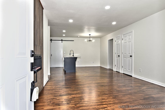 4636 E Independence St, Tulsa, OK 74115 - unfurnished living room with a barn door, recessed lighting, dark wood-style flooring, and a chandelier