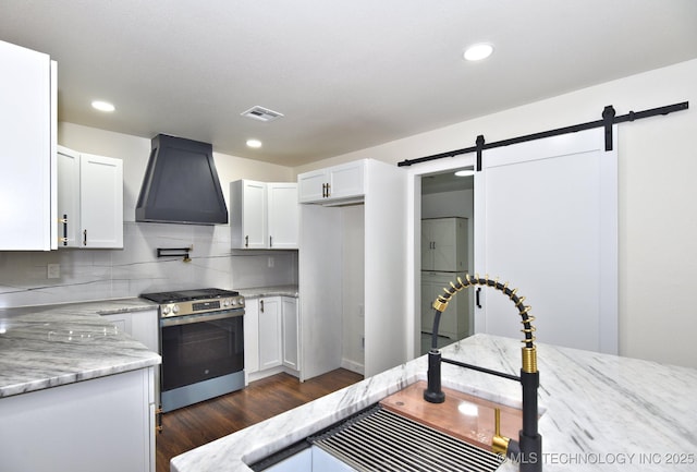 4636 E Independence St, Tulsa, OK 74115 - kitchen with stainless steel range with gas cooktop, exhaust hood, a barn door, light stone countertops, and recessed lighting